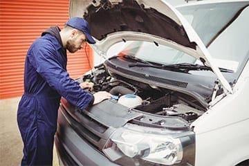 Man looking under the bonnet of a van