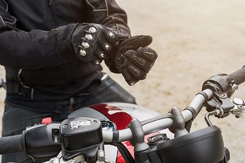 A man putting motorbike gloves on