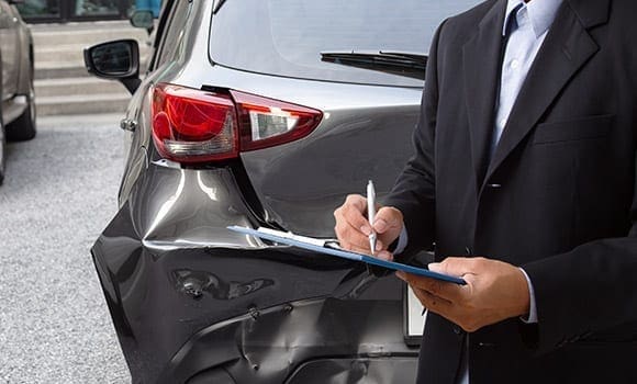 Man inspecting damaged car