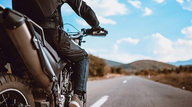 Someone on a motorbike on a country road