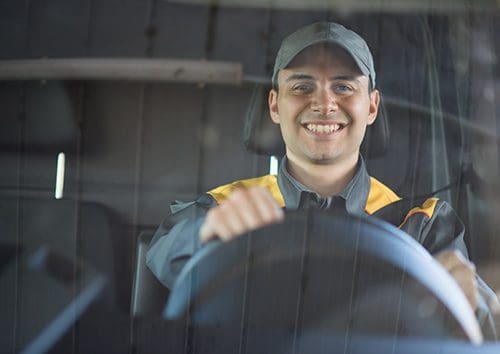a man smiling driving a van